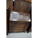 An oak stained writing desk or bureau having four drawers