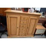 A modern golden oak effect cupboard having central drawer section, dimensions approx. W145 D52