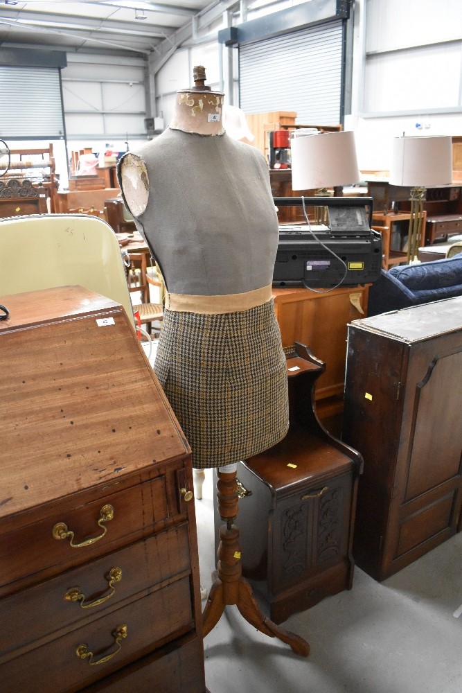 A vintage dressmakers dummy , female form,on wooden tripod base