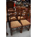 A set of four traditional oak ladder back dining chairs