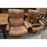 Two tan leather stressless armchairs and a footstool