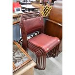 A set of six vintage stacking chairs, having read leather seats and tubular metal frames
