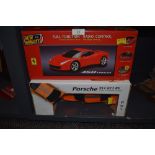 Two remote controlled cars in boxes, a Porsche 911 GT3 and a Ferrari 458 Italia.