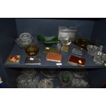 An assortment of vintage glass ash trays and cigarette cases.