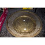 A large vintage brass Eastern styled table top and an embossed platter, possibly London scene.