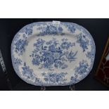 A large antique blue and white platter having transfer pattern of floral scene and birds.