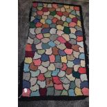 A vintage peg rug having colourful shell shaped sections, some wear to the edges in places..