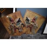 Two wooden shield decorative plaques, depicting knights on horseback.