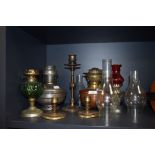 A collection of Vintage and antique oil lamps, chimneys, and candlestick holders some having arts