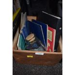 A box containing coins and coin albums, also included are reference books.