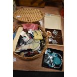 A wickers box of buttons and haberdashery and some costume jewellery.