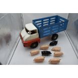 A Triang tin plate Farm Lorry with 6 pink and two black plastic pigs,having blue body, white cab and