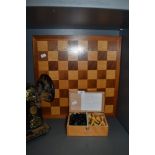 A wooden chess board and box of chess pieces.