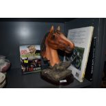 A mixed collection of items including a horse head figurine, a book on British bikes and one on