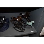 Four decorative metal rocking horses.