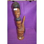 An exotic wood hand carved totem of figure heads