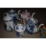 Four tea pots having blue and white transfer patterns and one with red and white pattern amongst