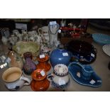 An assortment of studio pottery pieces among which are vases, candle sticks and bowls, a mix of