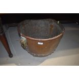 A traditional copper cauldron, having brass lion mask handles, drainage holes drilled to base,