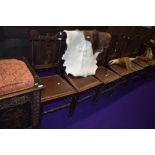 A set of six traditional oak dining chairs, having leather studded seats and interesting 'F' back,