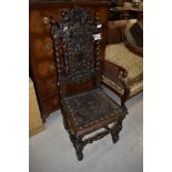 A Jacobean style oak hall chair having detailed dragon and angel leather work to seat and foliate