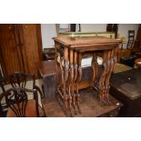 An early 20th Century walnut quartetto nest of tables on scroll frames