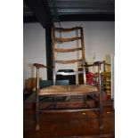 A traditional stained frame rush seated ladder back carver chair