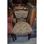 A pair of 19th Century mahogany dining chairs, having stuffed rail back and seats, on fluted legs