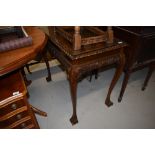 A traditional mahogany effect side table on scroll legs with ball and claw feet, glass top,