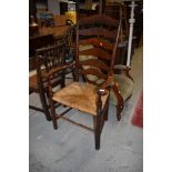 A traditional oak ladder back rush seated country carver chair