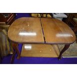 A light stained mahogany winding dining table with leaf
