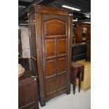 An early 20th Century oak hall robe, having panelled doors and carved detail