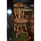 A Victorian sewing or craft chair having turned oak frame work adjustable seat with cast and glass