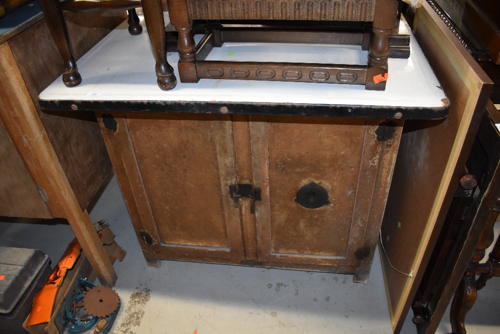 A vintage kitchen or industrial cabinet, having enamelled top, and vented double cupboard under