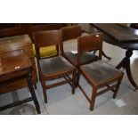 A set of four mid 20th Century oak dining chairs, having velvet upholstered seats and solid backs