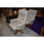 A pair of Stressless style cream leather easy chairs
