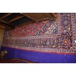 a large carpet square rug in red and dark blue grounds