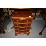 A reproduction yew wood, serpentine front 4 drawer dwarf chest, width approx. 41cm , with label