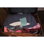 A suitcase containing vintage and retro clothing alongside and unfinished Welsh wool style cape.