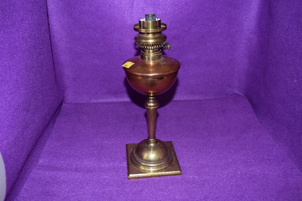 an antique oil burning lamp having copper well with brass fitments by WAS Benson