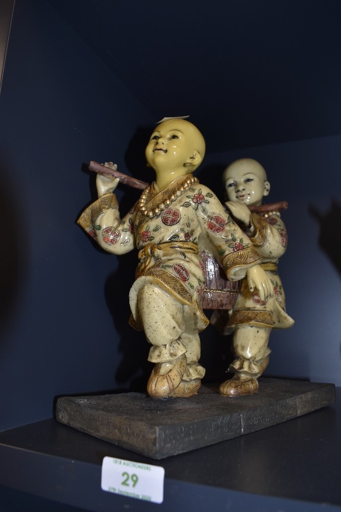 A Figural base of two Chinese water carriers hand decorated