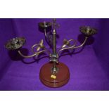 An arts and crafts brass candlestick holder having three swinging arms with ivy decoration and cross