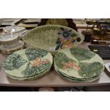 A plate in the shape of a leaf with hand painted floral design to end with embossed basket weft