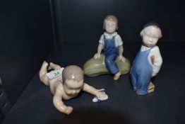 Three Royal Copenhagen Figures, Crawling Baby, model no 1739, length 15cm, Boy with Brush, model