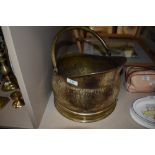 A brass coal bucket with handle.