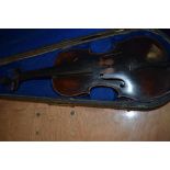 A distressed dark stained 19th Century violin having lion mask scroll, on piece back and traditional