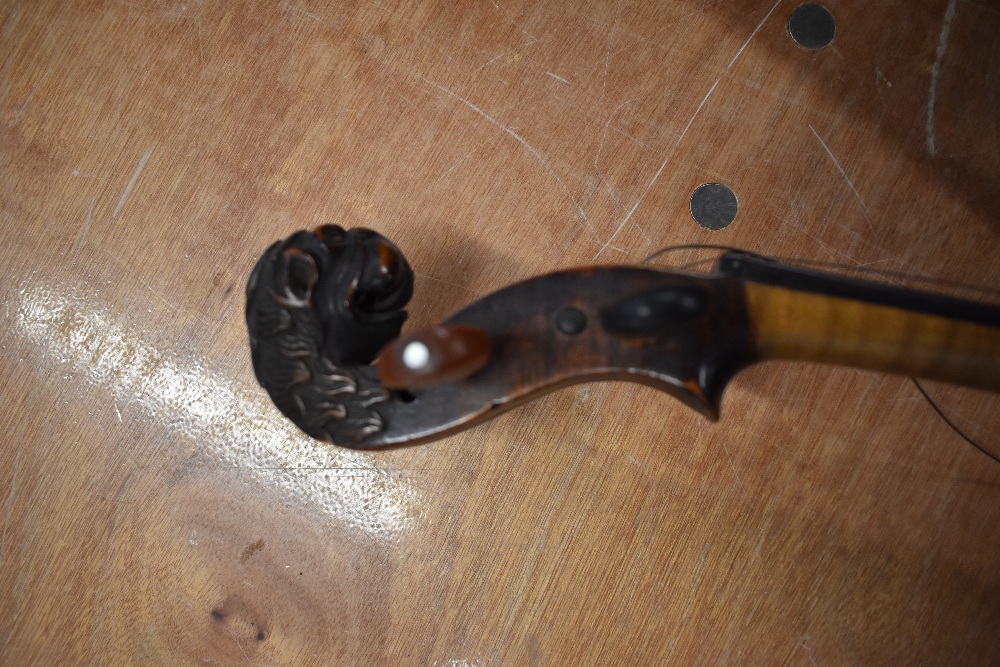 A distressed dark stained 19th Century violin having lion mask scroll, on piece back and traditional - Image 3 of 3