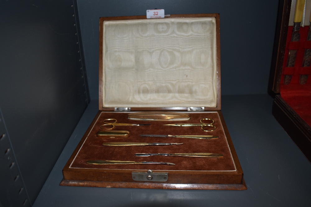 A manicure set with walnut veneer case and brass pieces