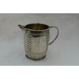 An Arts & Crafts silver cream jug by Liberty & Co having hammered and pressed leaf and dot