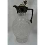 A cut glass claret jug of oval form having chequered decoration and plated handle and lid with